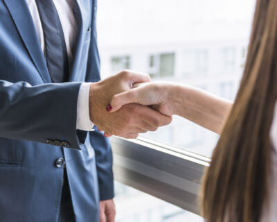 close up businesswoman businessman shaking hands
